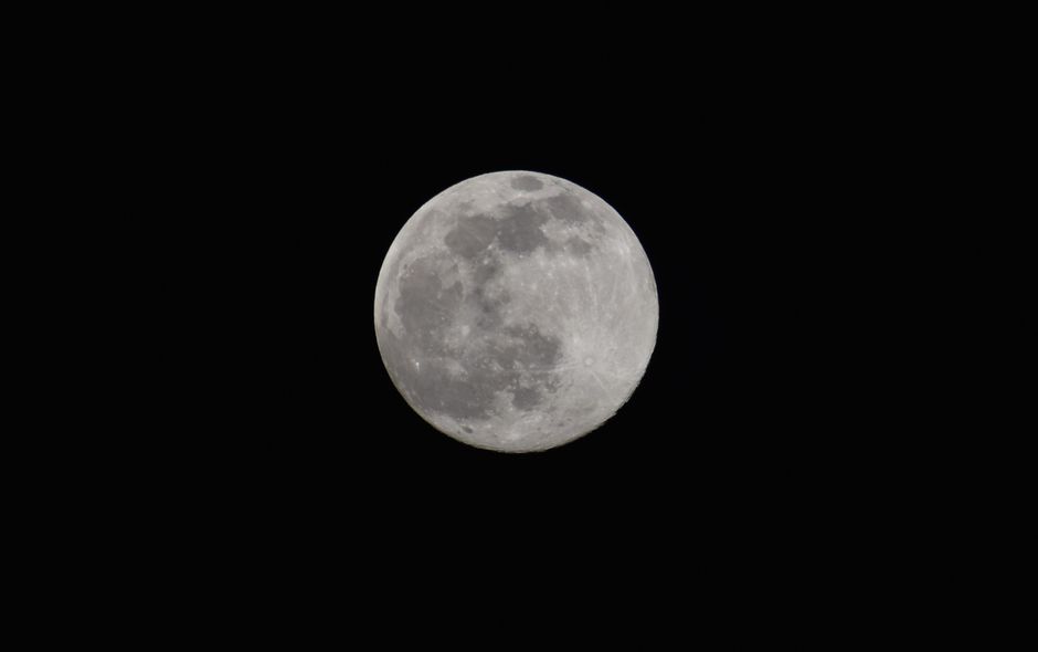 Fotomural Cautivador primer plano de una luna llena contra un cielo nocturno oscuro.