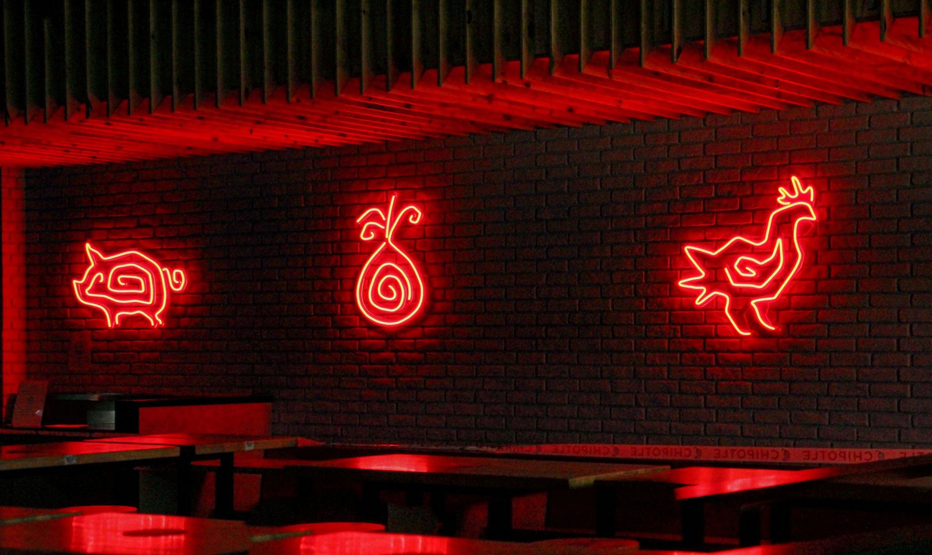 El Cockfight neon sign glowing outside a historic downtown Austin corner building at night