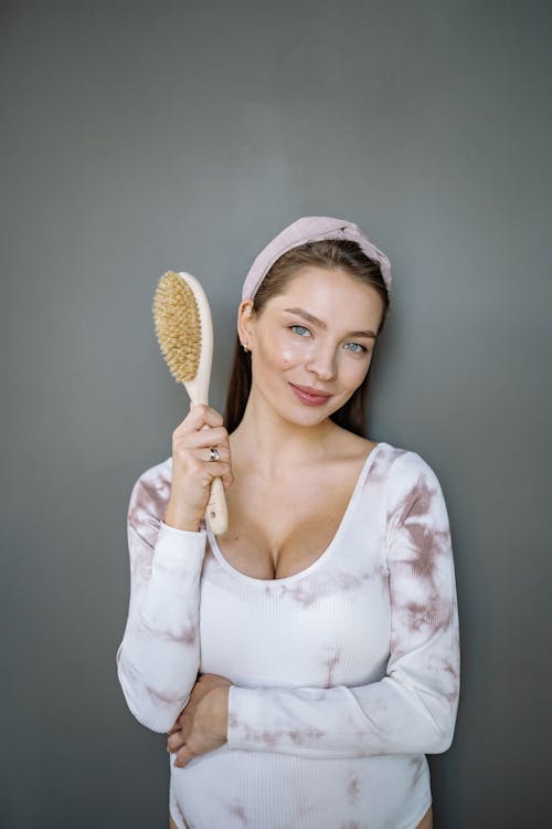 A Woman in a Sweater Holding a Hair Brush