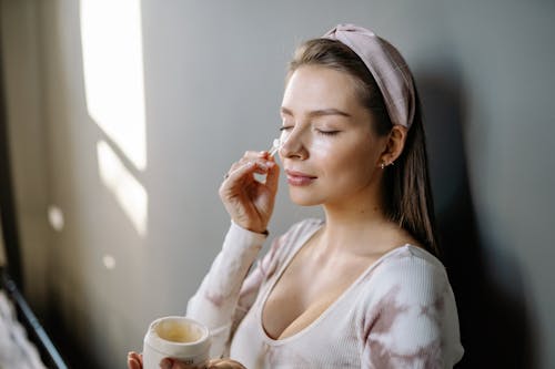 Free Photo of a Woman Applying Cream on Her Face Stock Photo