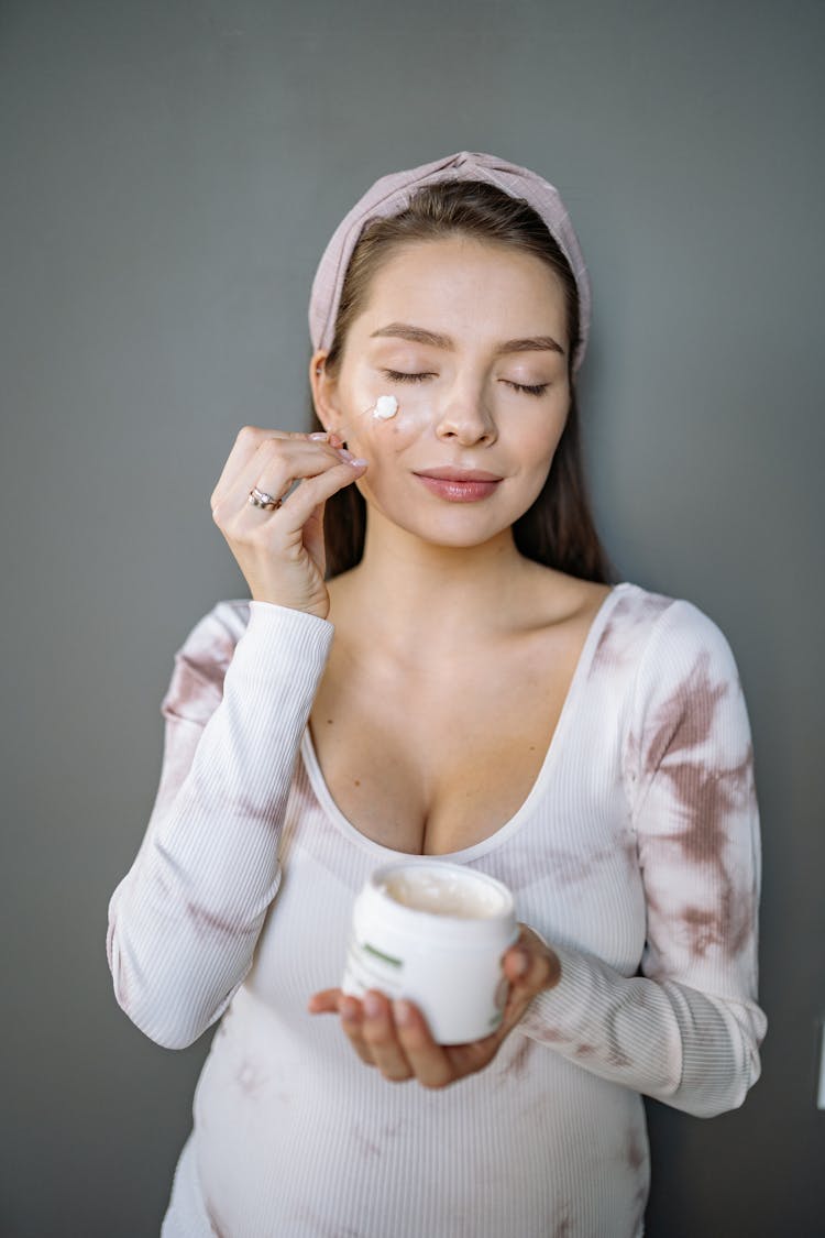 A Woman Putting Cream On Her Face