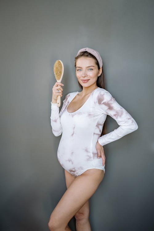 Woman Posing While Holding a Body Massage Brush 
