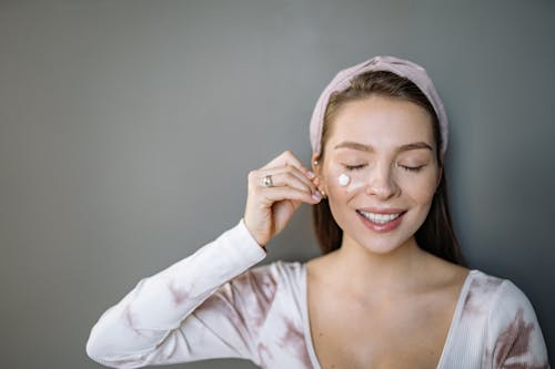 A Woman Putting a Cream on Her Face
