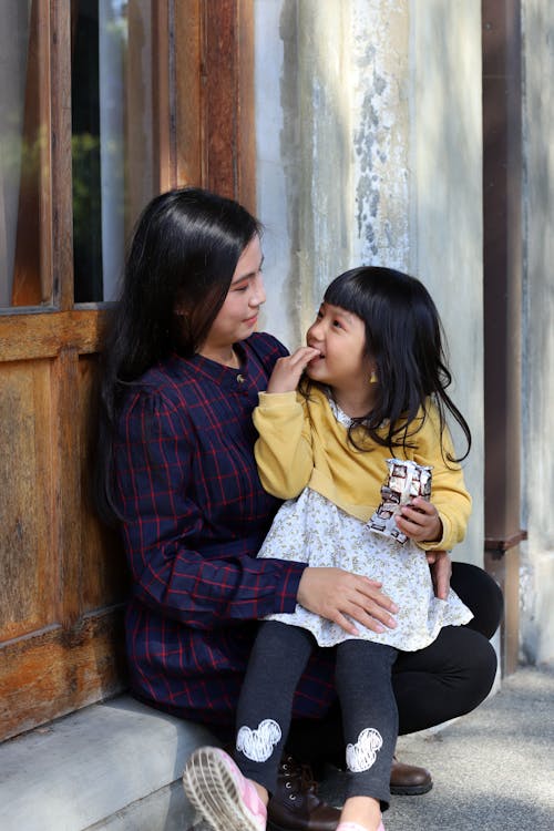 A little Girl Sitting on the Lap of a Woman