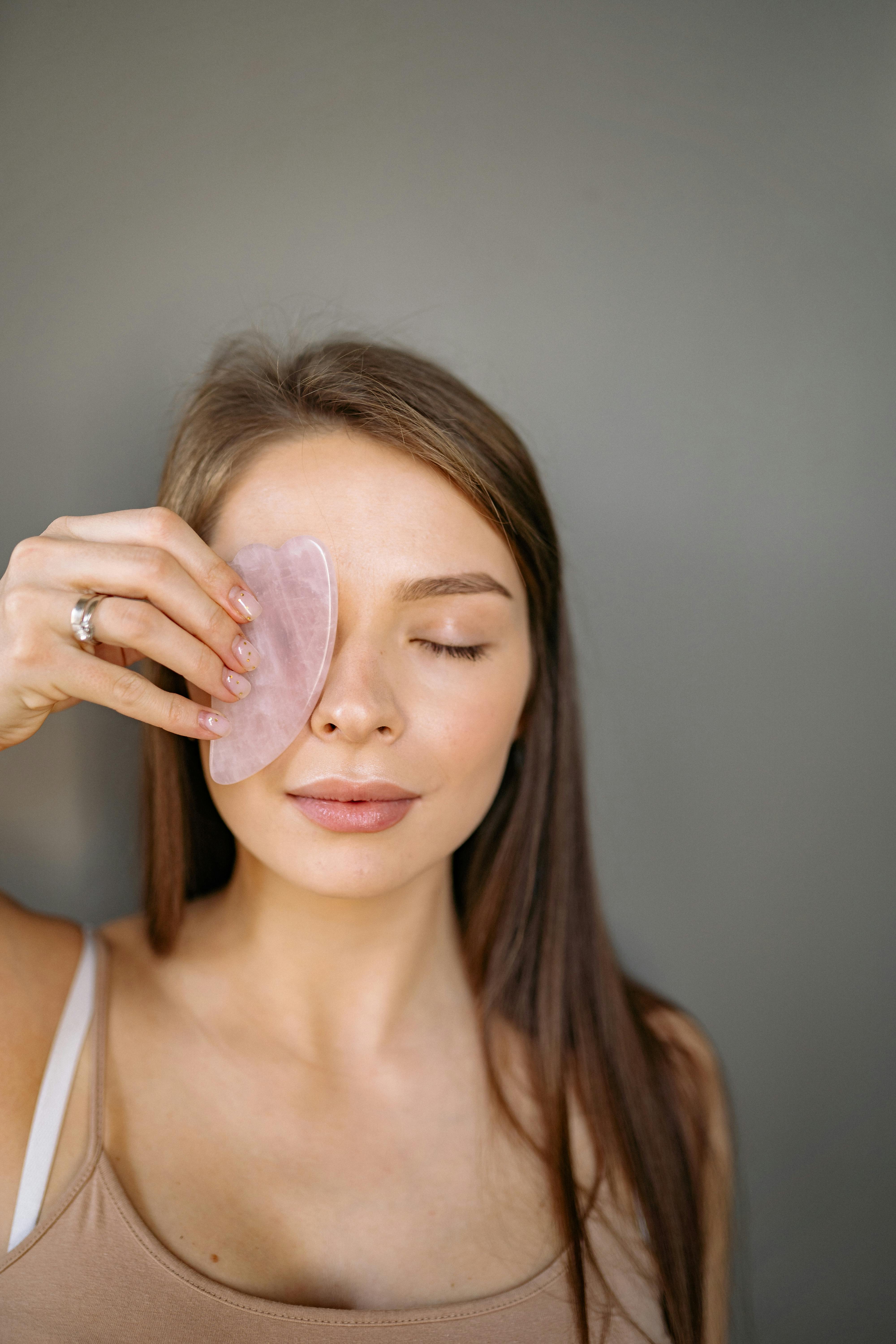Woman Holding a Jade Facial Stone Covering Her Eye · Free Stock Photo