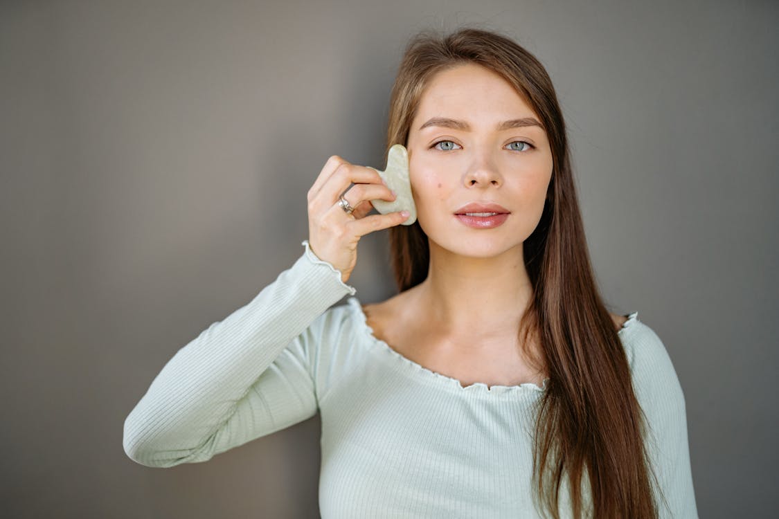 Woman Holding a Piece of Jade Stone on to Her Face