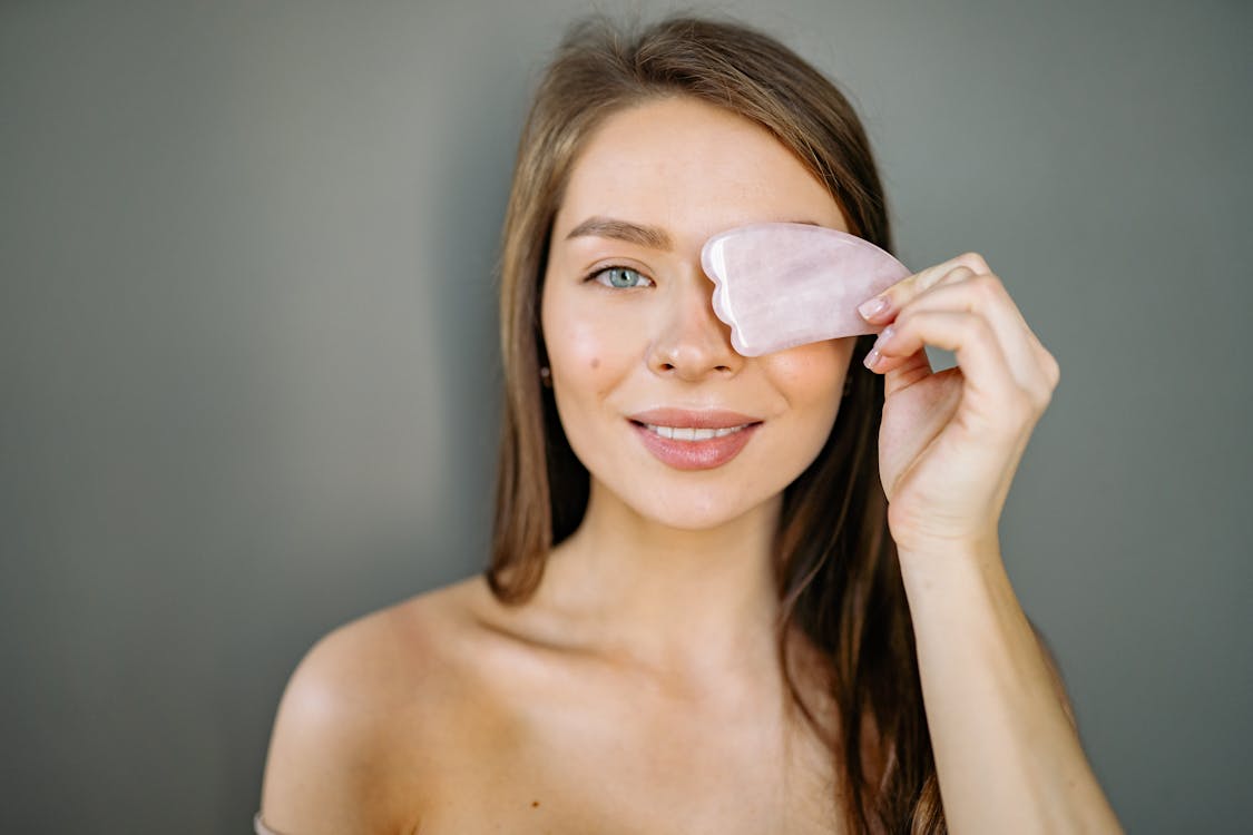Woman Holding a Piece of Stone on to Her Eye