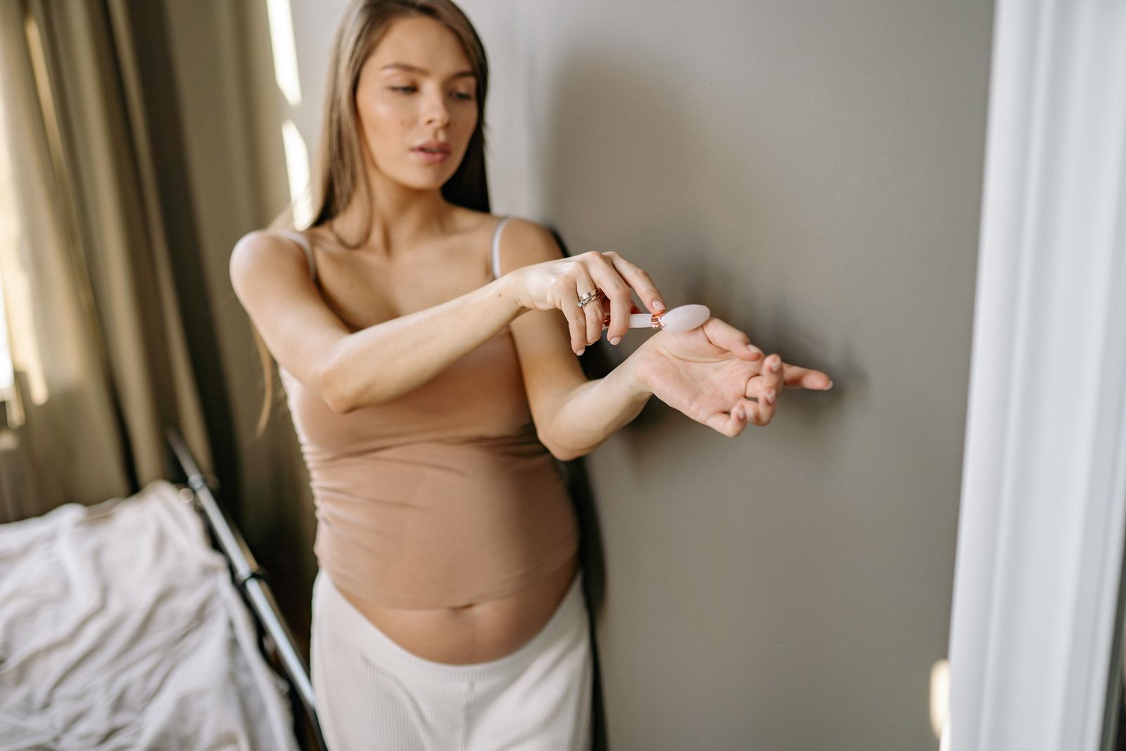 Pregnant woman enjoying a quiet self-care moment in a bedroom