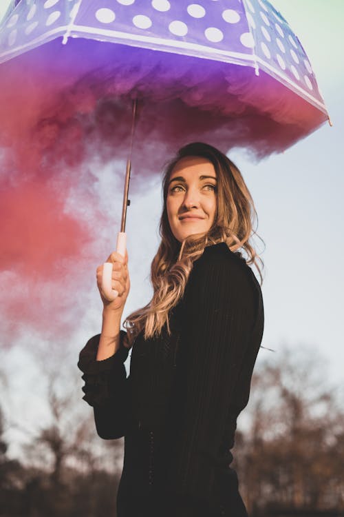 Free Portrait of a Young Woman Holding a Smoking Umbrella Stock Photo