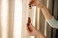 Person Holding Brown Glass Bottle