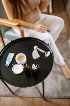 A serene setup of skincare essentials and a jade roller on a round table, embodying self-care.