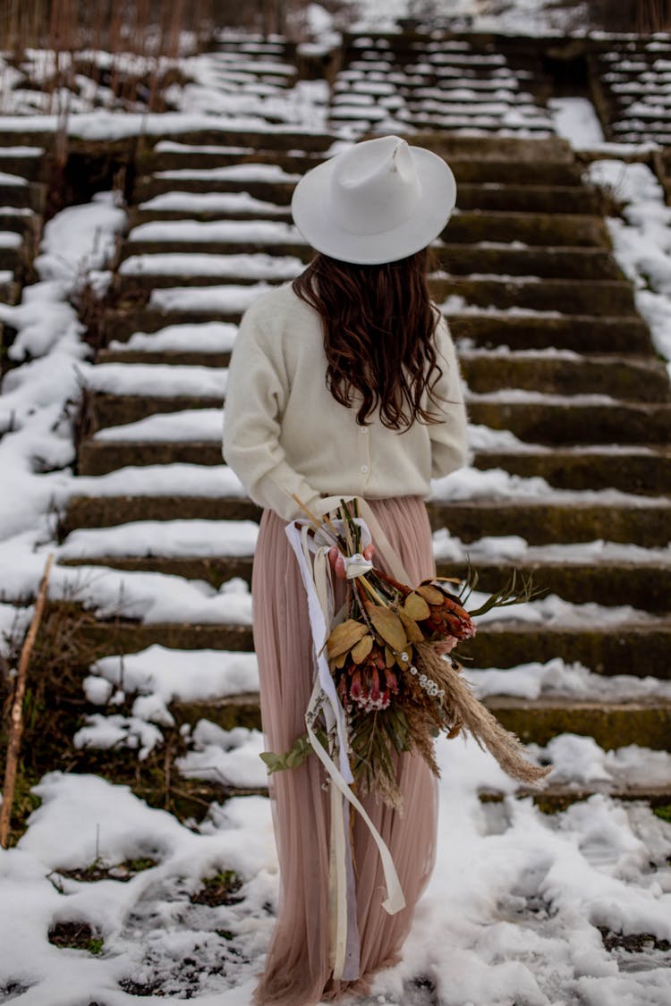 Woman Holding A Bouquet Of Dry Flowers Standing Outdoors In Winter 