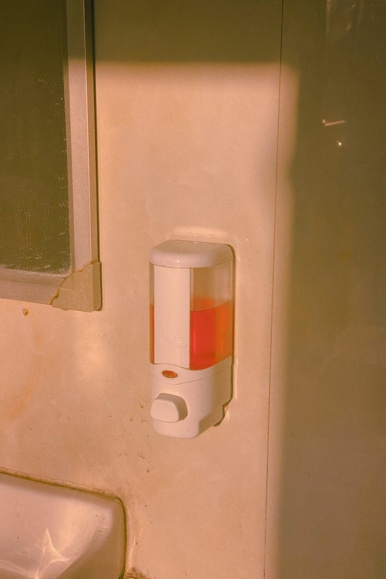 A Soap Dispenser Mounted On The Wall