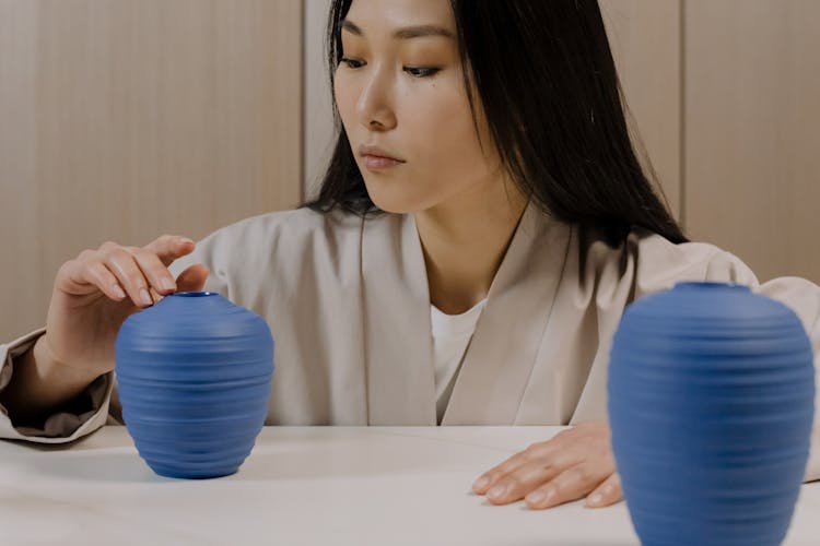 A Woman Touching A Blue Clay Jar