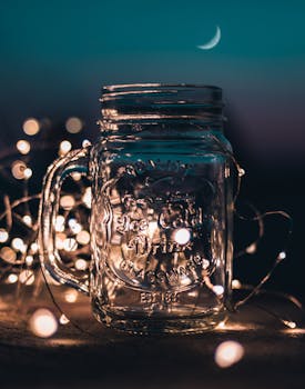 shallow focus photograph of clear glass mason jar with fairy lights