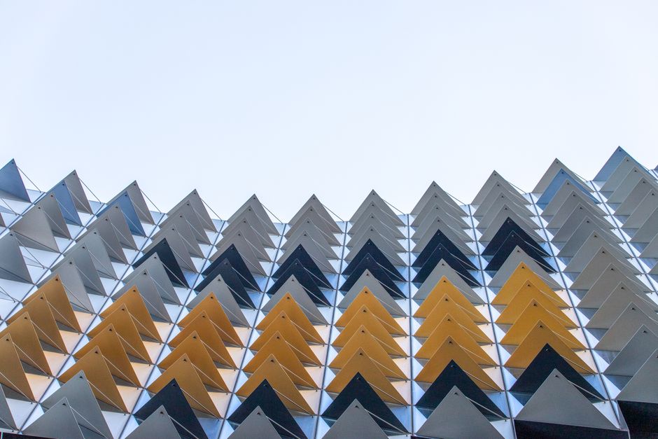 Low angle view of a contemporary facade featuring geometric triangle patterns.