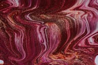 Bright mixed wet dyes spilled on surface and forming abstract background