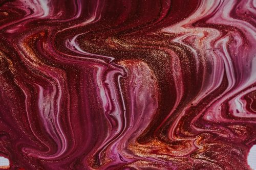 Free From above closeup of abstract background of shiny colorful acrylic paints with golden sequins blending with each other Stock Photo
