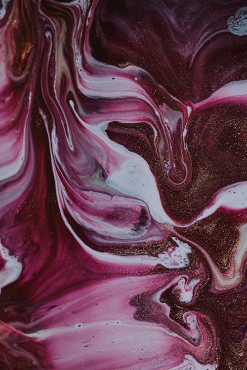 Top view of messy purple and white paints spilling on surface and forming chaotic swirls as abstract background