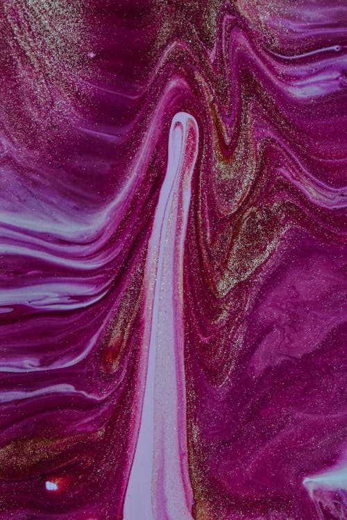 From above closeup of glossy surface of white and fuchsia nail polish with golden glitters as abstract background