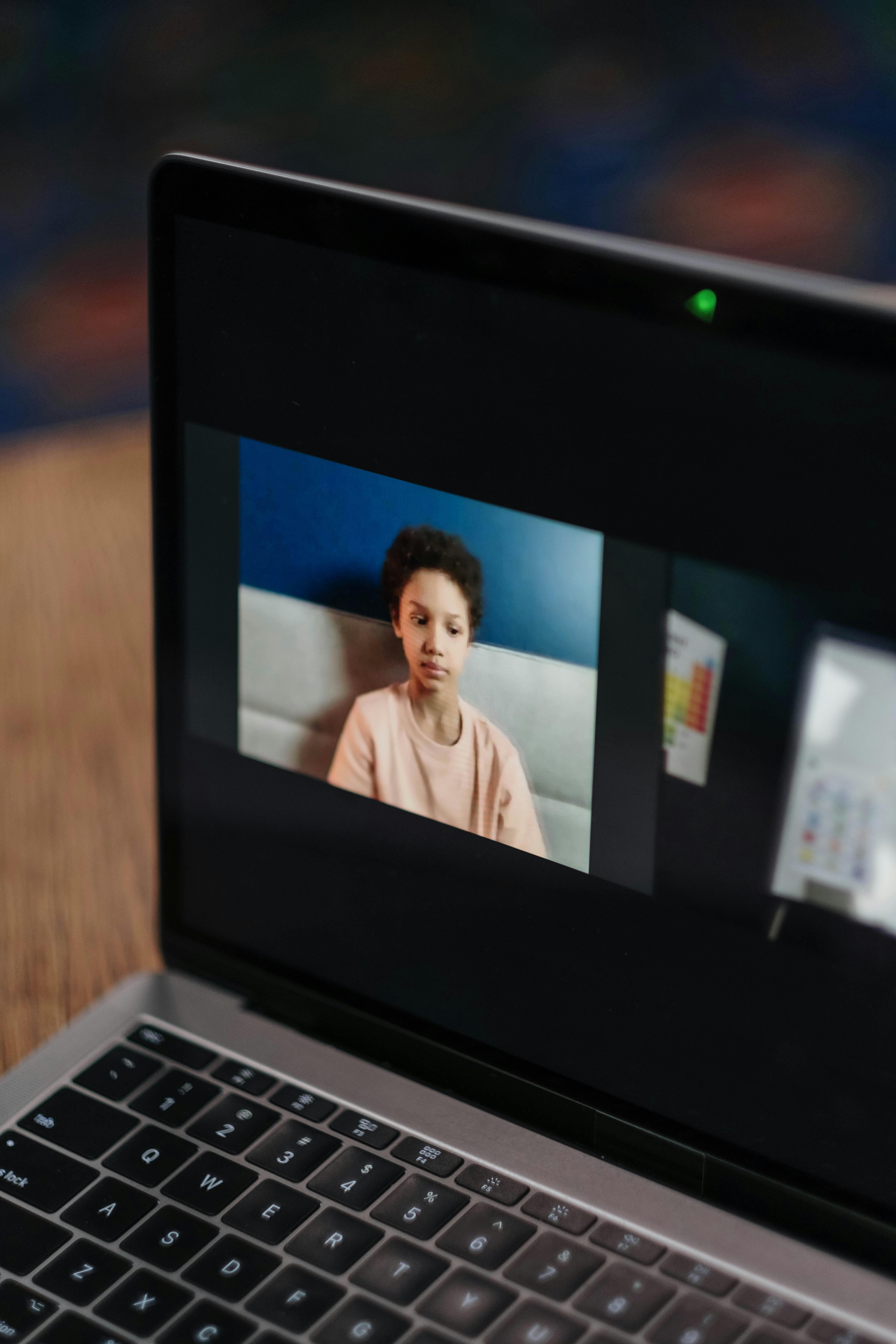 photograph of a kid on a laptop s screen