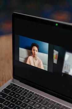 A young African American girl participates in an online class at home on a laptop.