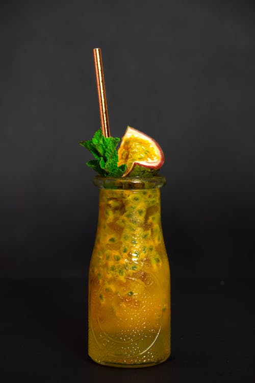 Photo of a Glass with an Alcoholic Drink and a Metal Straw