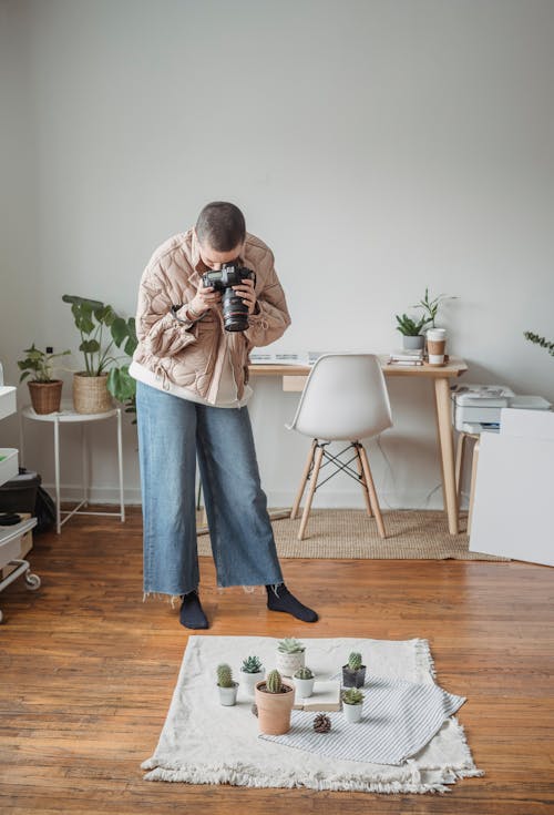 Free Man Holding a Camera while Taking Picture of Cactus Plants Stock Photo