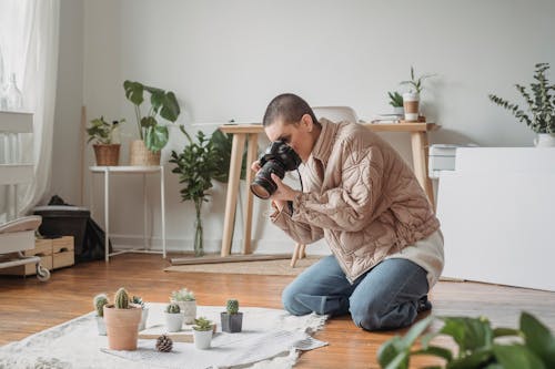 Free A Woman in a Beige Jacket Taking a Photo of Succulents Stock Photo