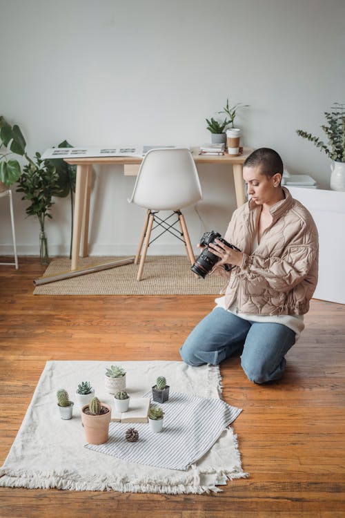 Photo of a Woman Kneeling Near Succulent Plants