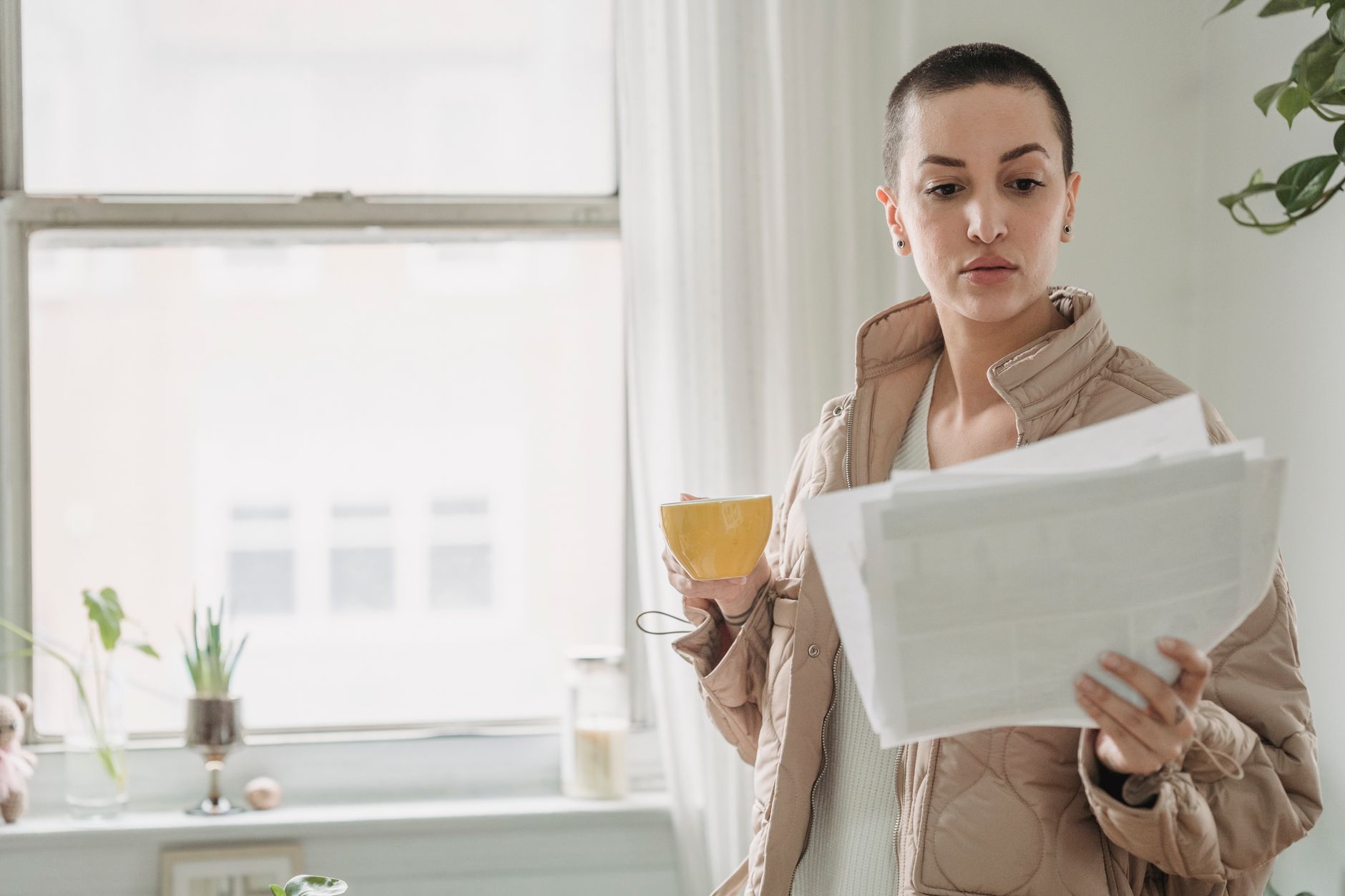 Kvinde studerer banktilbud og gebyroversigt ved kaffe