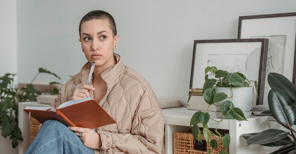 A person sitting in a church pew, holding a journal and pen, looking thoughtful and peaceful