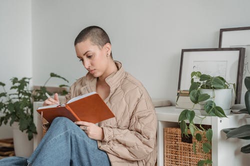 Attentive woman writing in diary at home