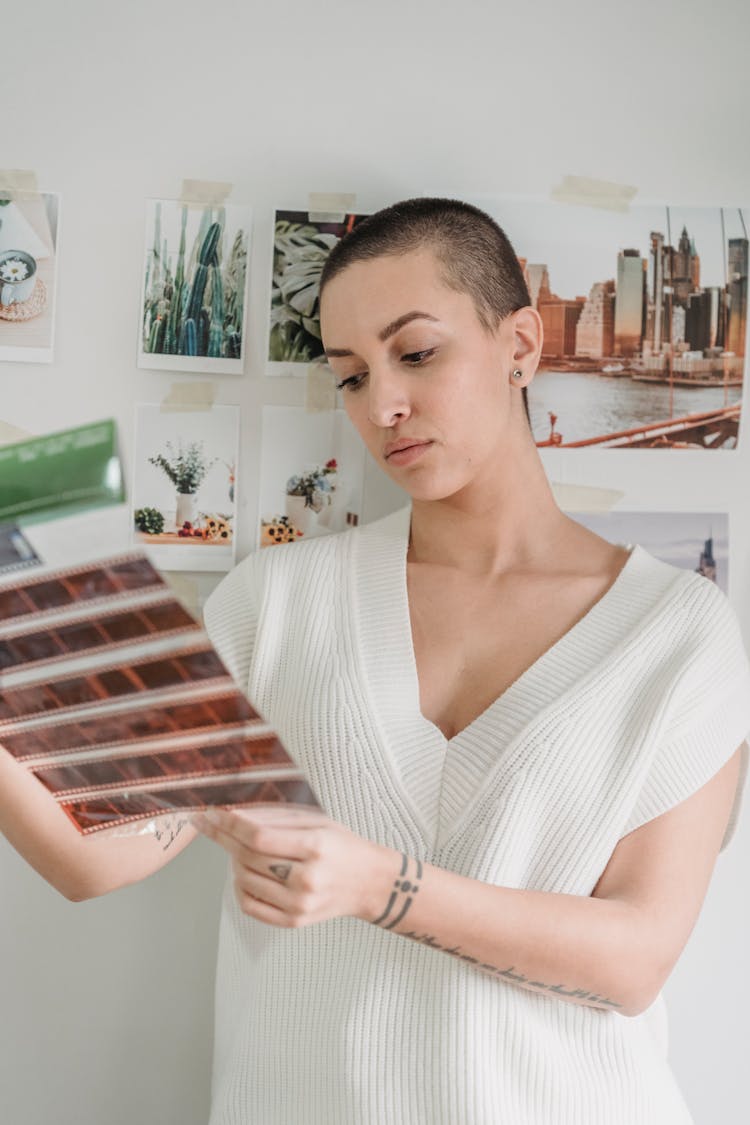 Serious Young Woman Choosing Images From Film Tapes In Photo Studio