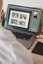 Unrecognizable person working on laptop and choosing photos