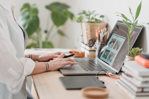 Free Woman working retouching photo on laptop at convenient workplace Stock Photo