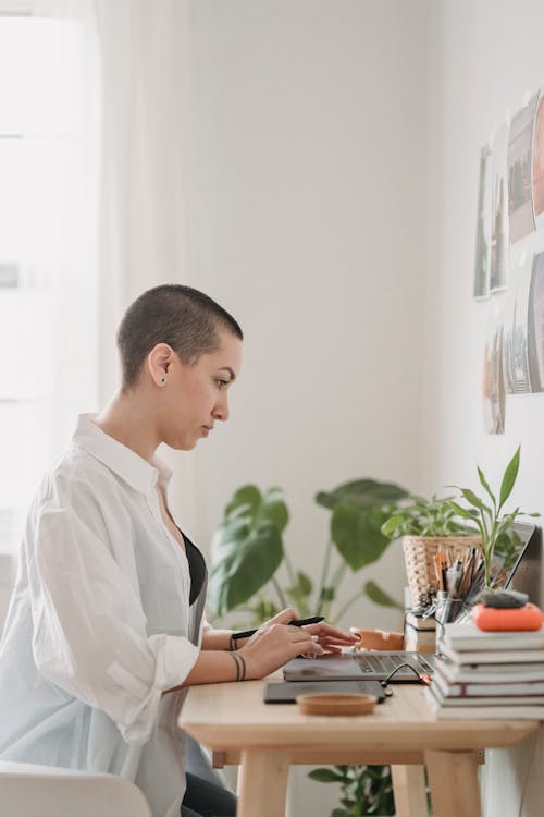 Serious woman browsing laptop while working attentively