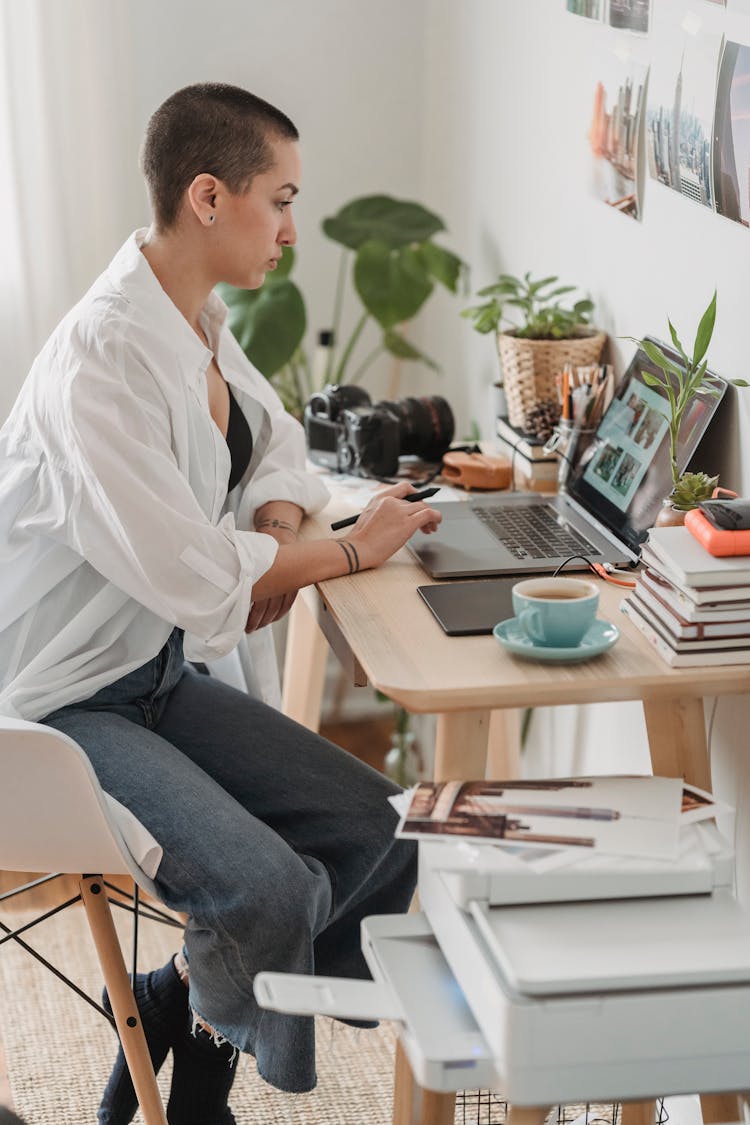 Focused Female Freelancer Editing Photos On Laptop