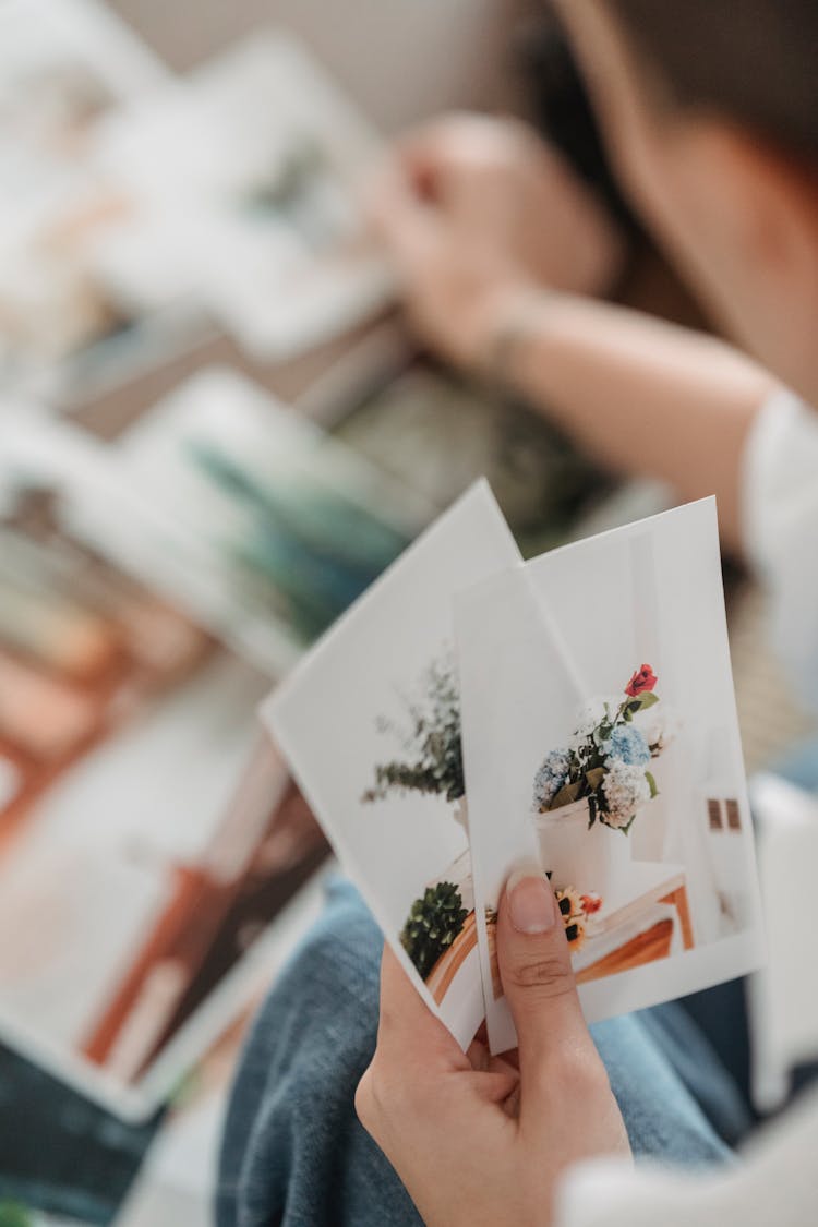 Woman Selecting Pictures Placed On Table