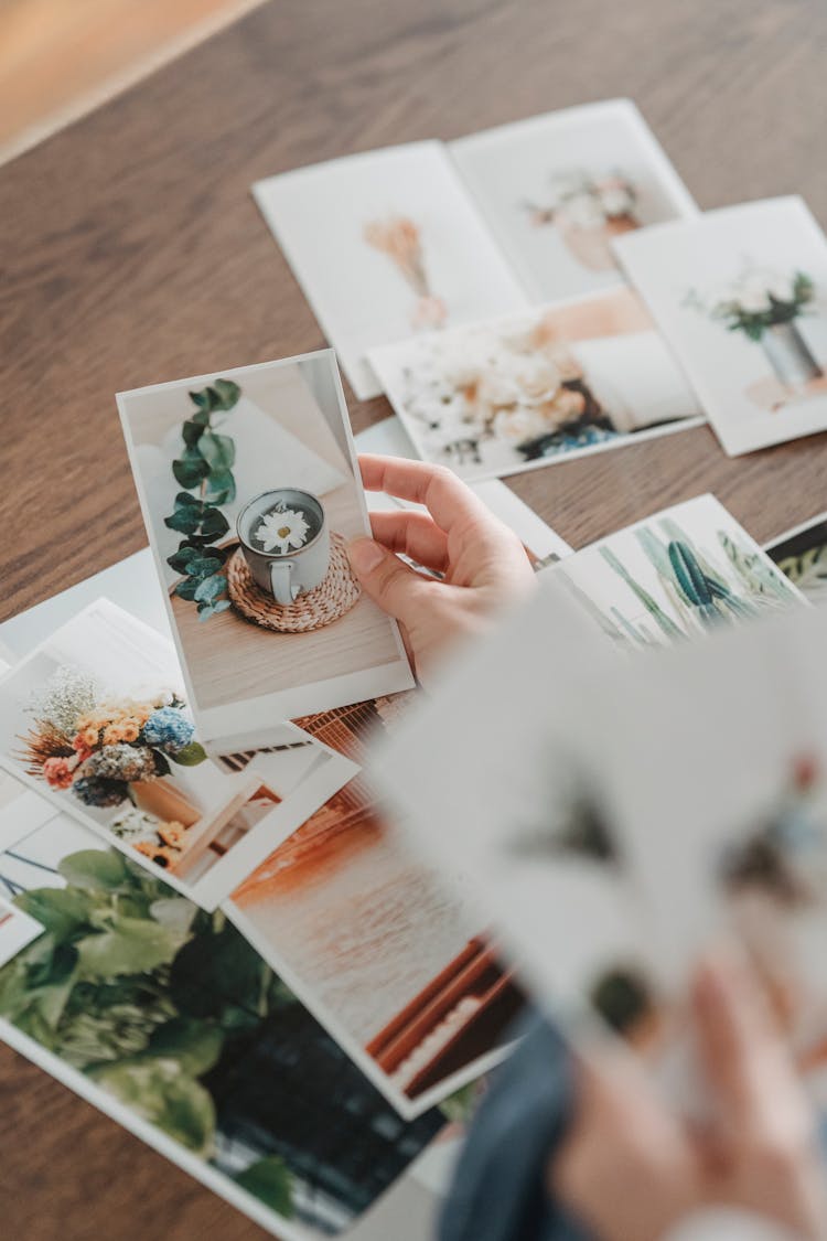 Crop Person Picking Photo Of Mug With Flower