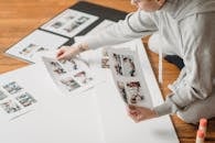 Crop woman creating photography collage on paper sheet