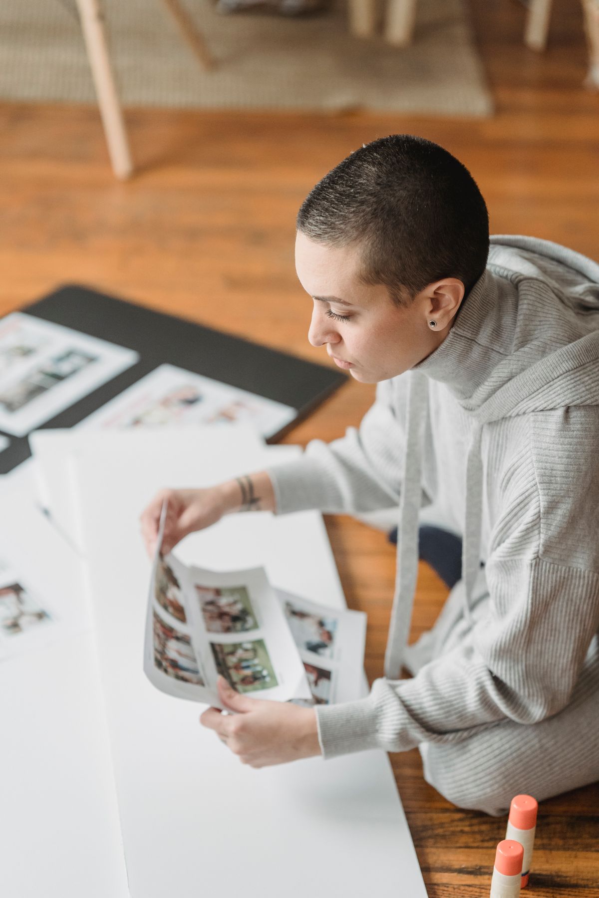 Person arranging photographs for a scrapbook at home