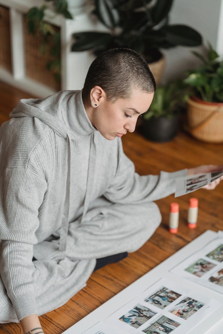 Woman With Crossed Legs Creating Photo Collage In House