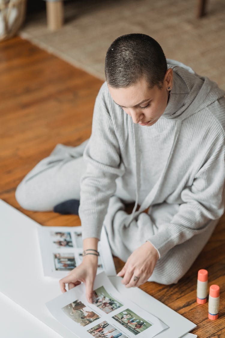 Woman Creating Photo Collage On Paper In House