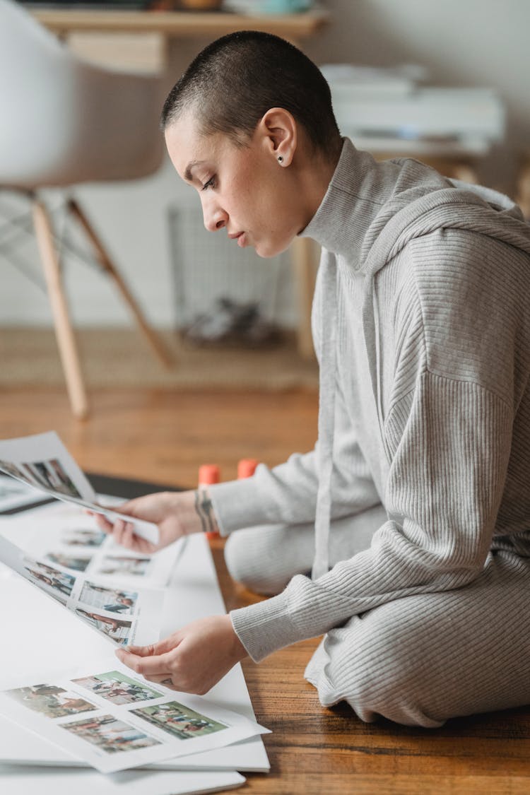 Woman Choosing Photos For Collage At Home