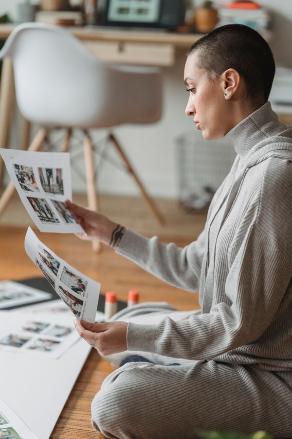 Flat lay of watercolor paintings, art prints, and a ceramic mug on a linen table representing online print on demand courses for artists