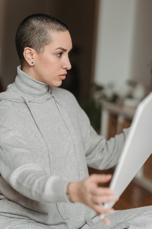 Concentrated woman looking at white canvas