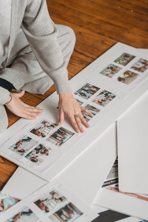 Free Crop person gluing family photos to poster Stock Photo