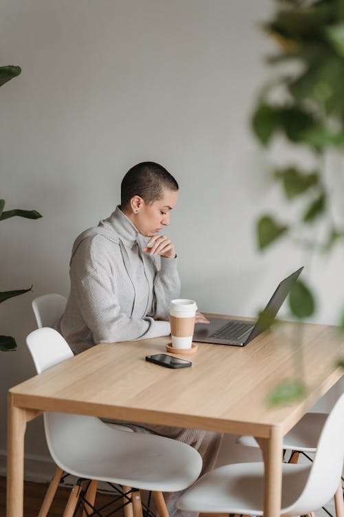 Female freelancer sitting at table with laptop