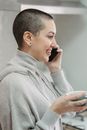 Smiling woman talking on smartphone in living room